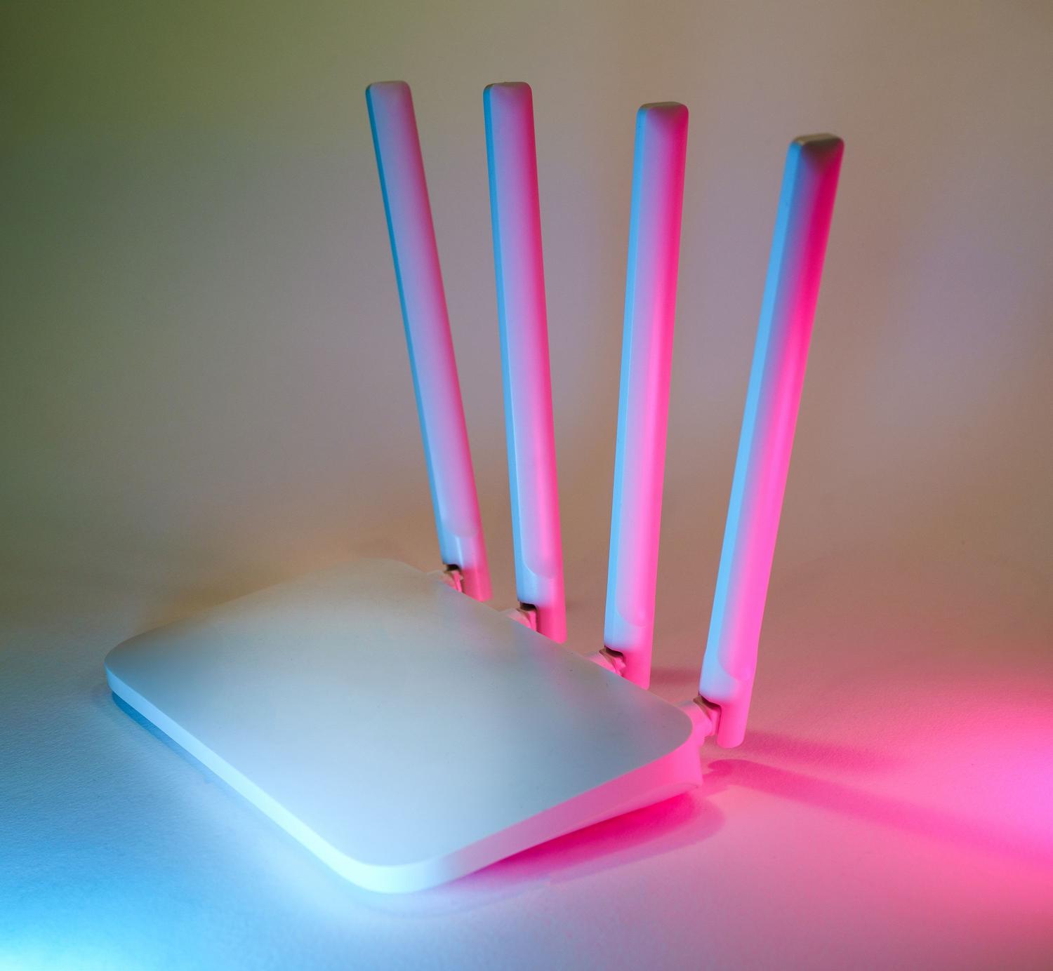Router inalámbrico de alta tecnología con iluminación LED de neón, sugiriendo alta velocidad.